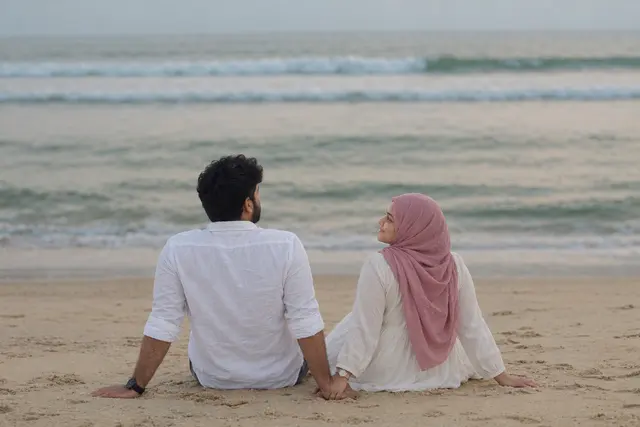 Holding hands by waves: a couple photographed at The beach, Goa