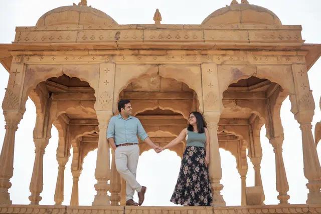 Holding hands by arches: a couple photographed at Bada Bagh, Jaisalmer