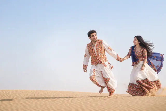 Running through sand: a couple photographed at Sam sand dunes, Jaisalmer